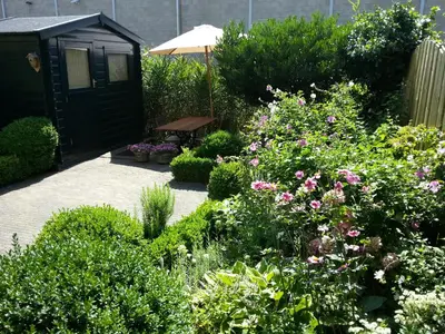 a garden with a bench and some bushes and flowers at Bed & Breakfast Frans Hals Haarlem in Haarlem