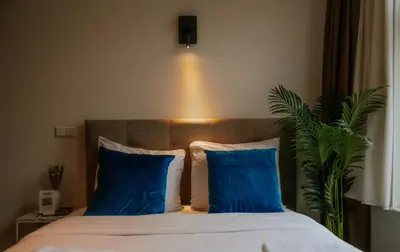 a bedroom with a bed with blue pillows and a plant at Hotel Heye 130 in Amsterdam
