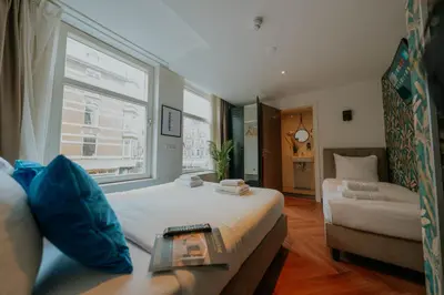 a room with a bed and a couch and a window at Hotel Heye 130 in Amsterdam