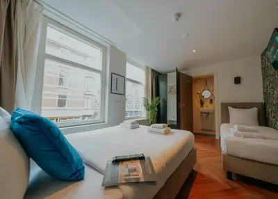 a bedroom with a bed and a window and a couch at Hotel Heye 130 in Amsterdam