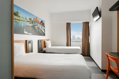a hotel room with two beds and a window at easyHotel Amsterdam Zaandam in Zaandam