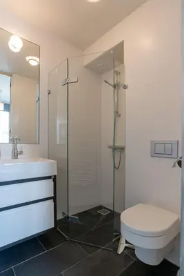 a bathroom with a toilet and a glass shower at Tweede Laurierdwarsstraat Apartment in Amsterdam