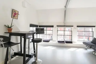 a room with a table and chairs and windows at Tweede Laurierdwarsstraat Apartment in Amsterdam