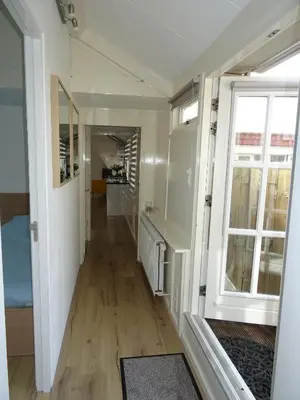 a hallway leading to a room with a window at BeachVibes in Egmond aan Zee