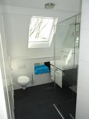 a bathroom with a toilet and a sink and a window at BeachVibes in Egmond aan Zee