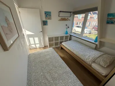 a small room with a bed and a window at BeachVibes in Egmond aan Zee