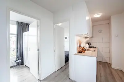 a kitchen with white walls and a counter top at Papillon flat in Zandvoort