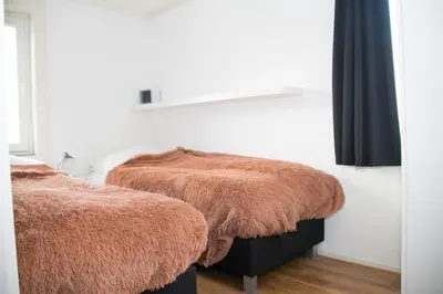 a bedroom with two beds with brown fur at Appartement Lefferts in Zandvoort