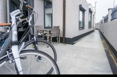 a bike parked on a sidewalk next to a building at Strandzand in Noordwijk aan Zee