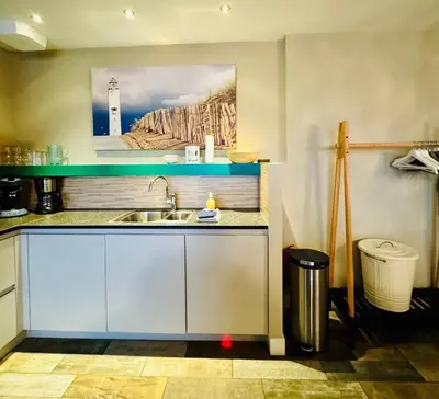 a kitchen with a sink and a picture of a lighthouse at Strandzand in Noordwijk aan Zee