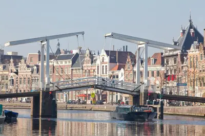 a bridge over a river in a city with buildings at Appartement Bos en Duin in Vogelenzang