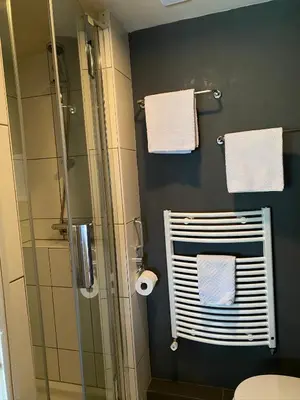 a bathroom with a shower and towels on a wall at Appartement Bos en Duin in Vogelenzang