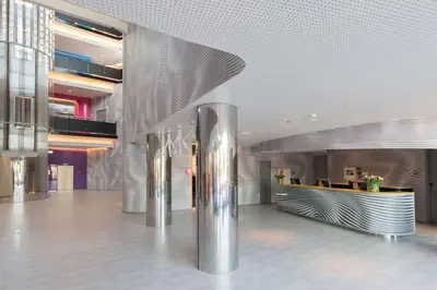 a lobby of a building with stainless steel columns at Park Inn by Radisson Amsterdam City West in Amsterdam