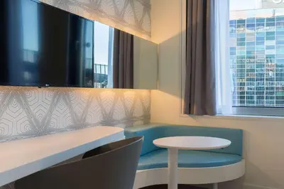 a room with a blue chair and a table and a window at Park Inn by Radisson Amsterdam City West in Amsterdam