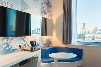 a room with a blue chair and a table and a window at Park Inn by Radisson Amsterdam City West in Amsterdam