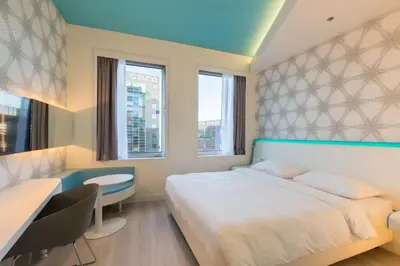 a bedroom with a bed and a desk and window at Park Inn by Radisson Amsterdam City West in Amsterdam