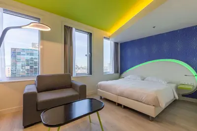 a bedroom with a bed and a chair and a table at Park Inn by Radisson Amsterdam City West in Amsterdam