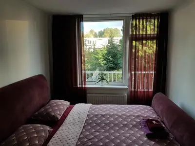 a bedroom with a bed in front of a window at Sunny Guesthouse in Amsterdam
