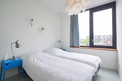 a bedroom with two beds and a window at Lake View Apartment Amsterdam in Amsterdam