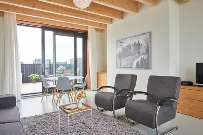 a living room with a table and chairs at Lake View Apartment Amsterdam in Amsterdam