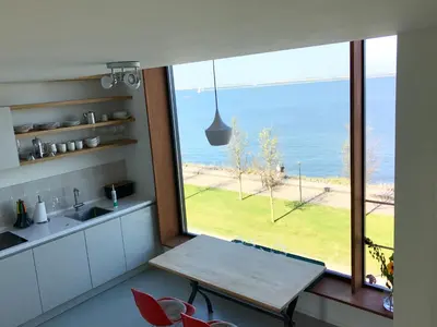 a kitchen with a table and a view of the ocean at Lake View Apartment Amsterdam in Amsterdam