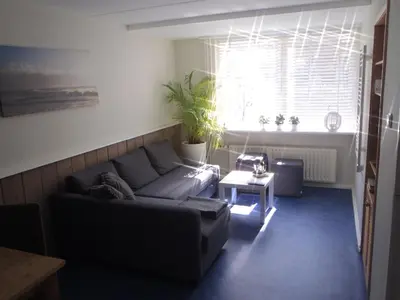 a living room with a couch and a window at Holidaytime in Zandvoort