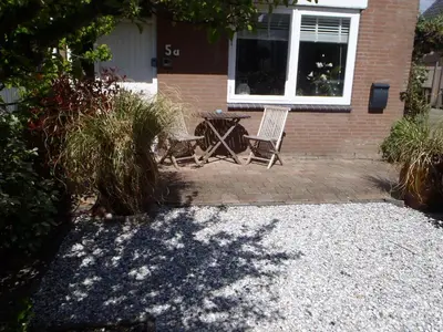 a patio with two chairs and a table in front of a house at Holidaytime in Zandvoort