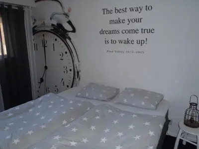 a bedroom with a bed with a clock on the wall at Holidaytime in Zandvoort