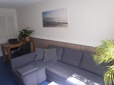 a gray couch in a living room with a table at Holidaytime in Zandvoort