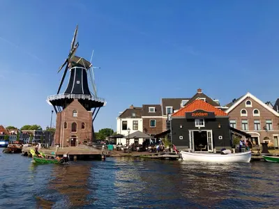 a windmill and a small house on the water at Maison Rue de la Mer in Zandvoort