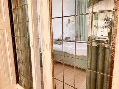 a room with a glass door leading to a bedroom at Maison Rue de la Mer in Zandvoort