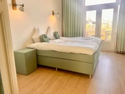 a small bed in a room with a window at Maison Rue de la Mer in Zandvoort