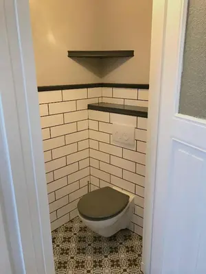 a bathroom with a toilet with a green seat at Maison Rue de la Mer in Zandvoort