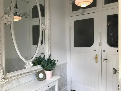 a bathroom with a mirror and a plant on a counter at Maison Rue de la Mer in Zandvoort