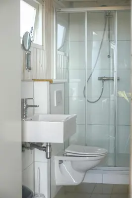 a bathroom with a toilet and a sink and a shower at Kusthuisjes in Katwijk