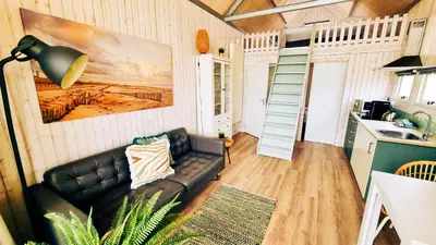 a living room with a couch and a kitchen at Kusthuisjes in Katwijk