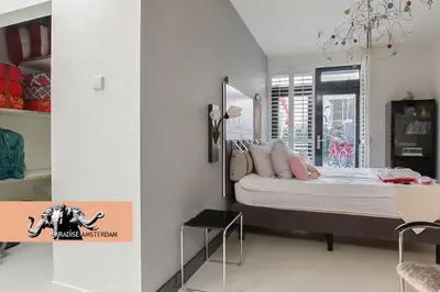 a bedroom with a bed and a table and a window at Paradise Amsterdam bungalow of 80 m2 with private pool - inclusive, parking, use of bikes, tourist tax and much more in Zandvoort