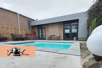 a swimming pool with a sign in front of a house at Paradise Amsterdam bungalow of 80 m2 with private pool - inclusive, parking, use of bikes, tourist tax and much more in Zandvoort