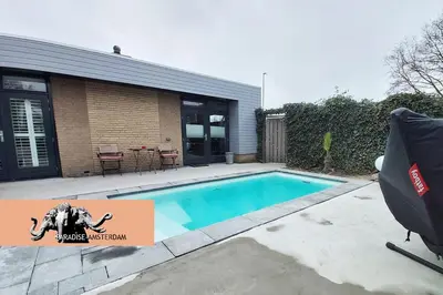 a swimming pool in front of a house at Paradise Amsterdam bungalow of 80 m2 with private pool - inclusive, parking, use of bikes, tourist tax and much more in Zandvoort