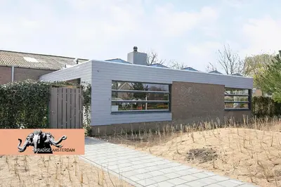 a house with a sign in front of it at Paradise Amsterdam bungalow of 80 m2 with private pool - inclusive, parking, use of bikes, tourist tax and much more in Zandvoort