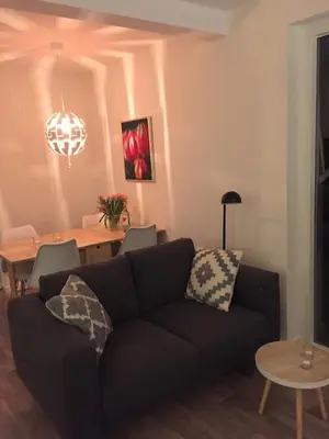 a living room with a couch and a dining room table at La Tulipe in Egmond aan den Hoef