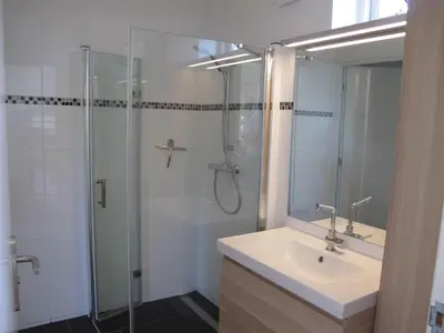 a bathroom with a sink and a glass shower at La Tulipe in Egmond aan den Hoef