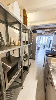 a large kitchen with a large metal shelf in it at JoyJoyJoy the White Wilde ecolicious studio in a historic Canalhouse from 1799 with terrace at the canals in Amsterdam
