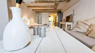 a white vase sitting on a table in a living room at JoyJoyJoy the White Wilde ecolicious studio in a historic Canalhouse from 1799 with terrace at the canals in Amsterdam