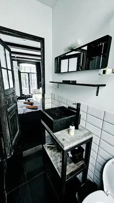 a bathroom with a sink and a mirror at JoyJoyJoy the Black Beauty ecolicious studio in a canal house with French balcony with view on the canals in Amsterdam