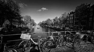 a group of bikes parked next to a canal at JoyJoyJoy the Black Beauty ecolicious studio in a canal house with French balcony with view on the canals in Amsterdam