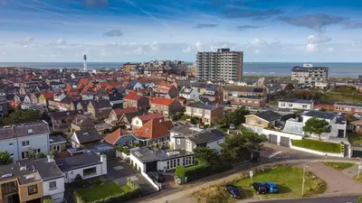 an aerial view of a city with houses and the ocean at Aan Zee en Duin in Egmond aan Zee