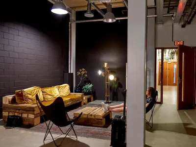a woman sitting in a room with a couch at Q-Factory Hotel in Amsterdam