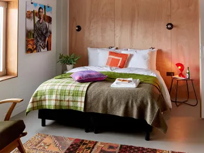 a bedroom with a large bed with a green blanket at Q-Factory Hotel in Amsterdam