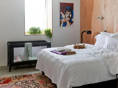 a bedroom with a bed with a teddy bear on it at Q-Factory Hotel in Amsterdam
